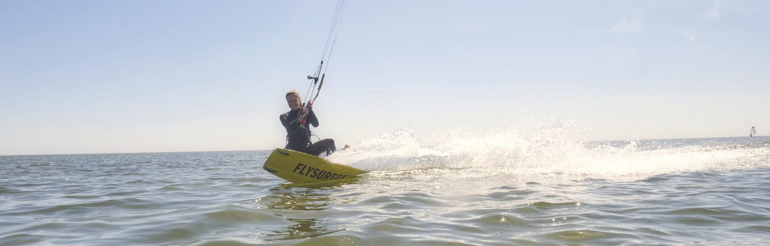 Kitesurferin faehrt im flachen stehtiefen Wasser des Stehreviers von Workum am IJsselmeer
