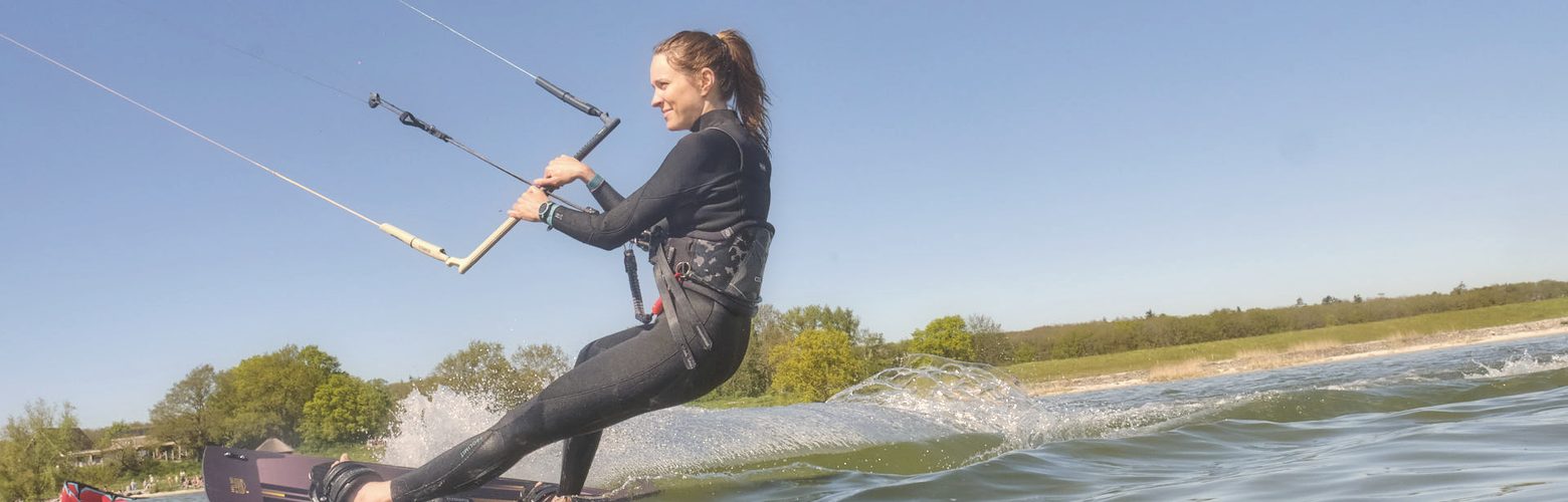 Kitesurferin faehrt im flachen Stehrevier am IJsselmeer bei Workum