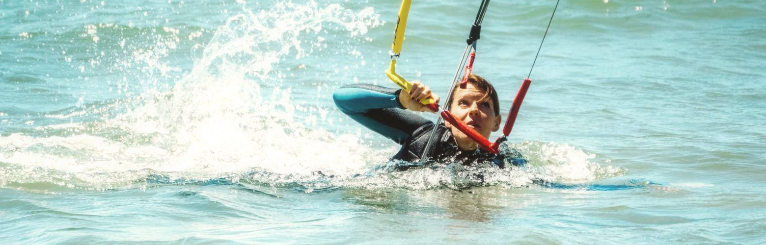 Kitekurs-Teilnehmer uebt den Bodydrag im tiefen Wasser der Nordsee in Petten